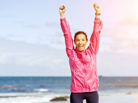 Young woman in sportswear standing at the seasideの写真素材