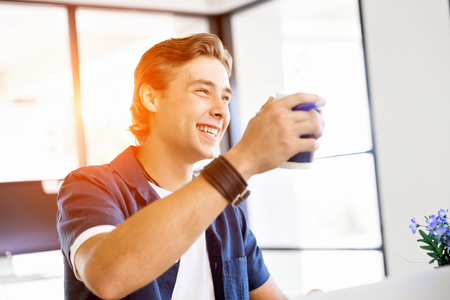 Young businessman in office with a mugの写真素材