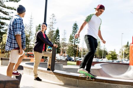 Teenage boys skateboarding outdoorsの写真素材
