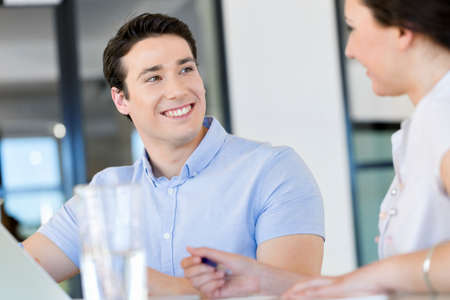 Image of two young business people in office