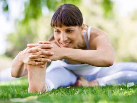 Young woman practicing yoga in the parkの写真素材