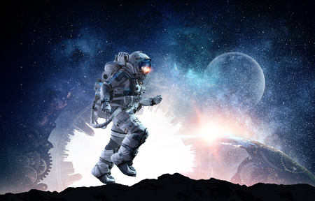 Astronaut in space suit running on planet surface.の写真素材