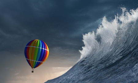 Color aerostat flying above stormy sea wavesの写真素材