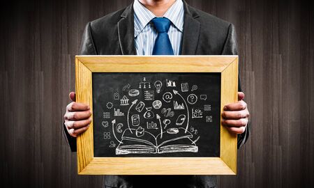 Handsome businessman holding wooden frame with business sketches. Mixed mediaの写真素材