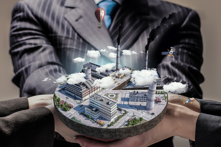 Mini industrial area presented in male palm. Mixed mediaの写真素材