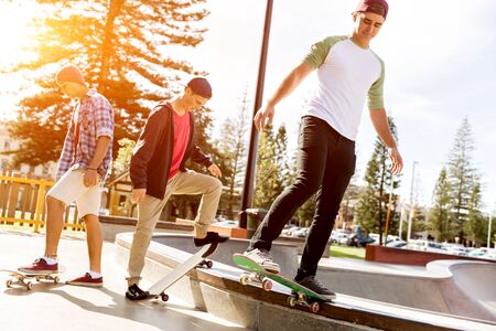Teenage boys skateboarding outdoorsの写真素材