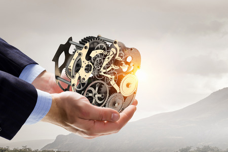 Cogwheel mechanism in hand. Mixed mediaの写真素材