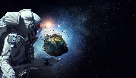 Astronaut holding Earth planet in palm.