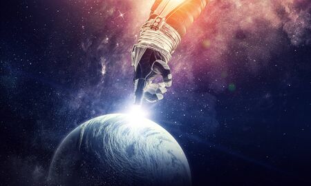 Close of astronaut robotic hand touching planet.の写真素材