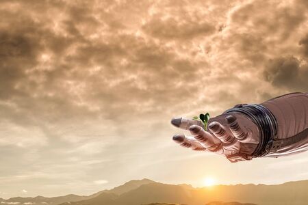 Hand of astronaut and green sprout. Mixed media