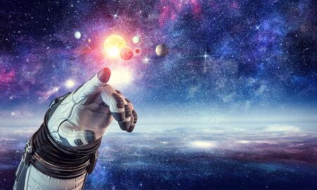 Close of astronaut robotic hand touching planet. Elements of this image furnished by NASA