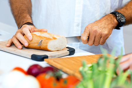 Male hands cutting breadの写真素材