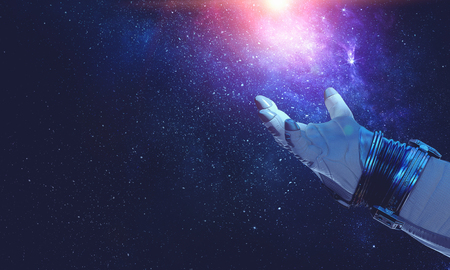 Hand of astronaut and glowing starry sky. Mixed mediaの写真素材