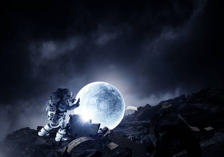 Astronaut in suit making planet roll. Mixed mediaの写真素材