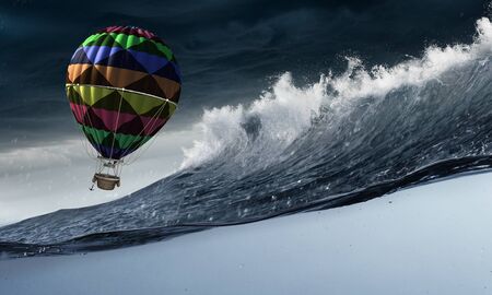 Color aerostat flying above stormy sea wavesの写真素材