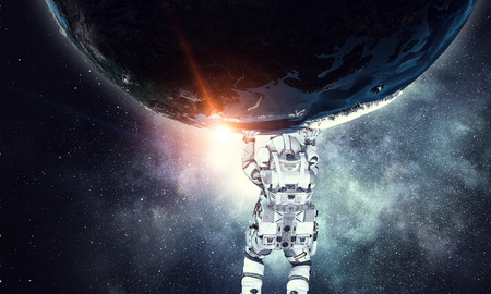 Astronaut lifting planet above head.