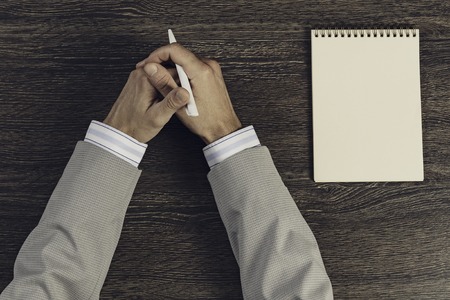 Top view of businessman at table with notepad and penの写真素材