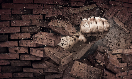Male hand breaking with fist brick wall. Mixed mediaの写真素材