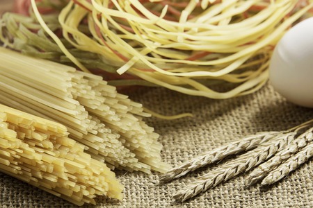 Dry spaghetti pasta and eggs on table ready for cookingの写真素材
