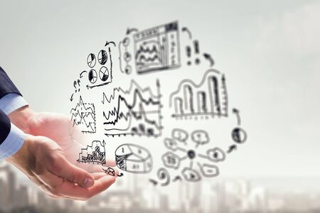 Close of hand presenting business sketches on palmの写真素材