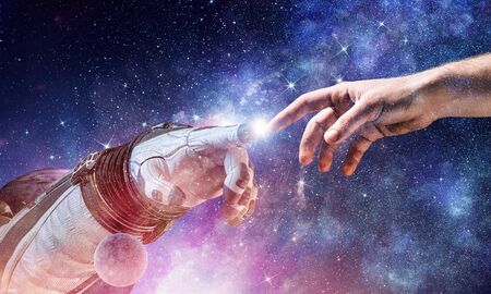 Astronauts hands in touch as symbol for creation. Mixed mediaの写真素材