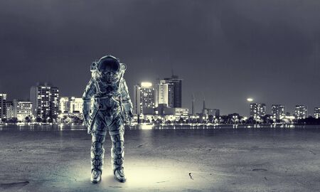 Spaceman in suit on cityscape background. Mixed mediaの写真素材