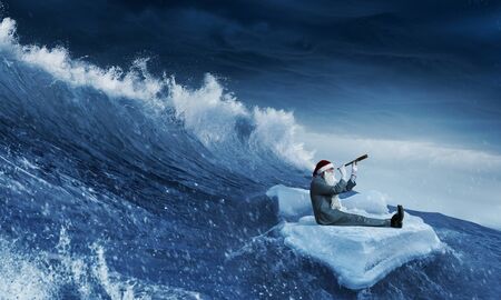 Santa floating in sea and looking in spyglass. Mixed mediaの写真素材