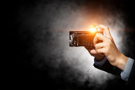 Close of businessman holding photo camera. Mixed mediaの写真素材