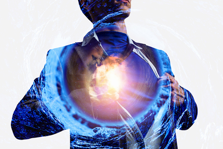 Young businessman acting like super hero and tearing his shirtの写真素材