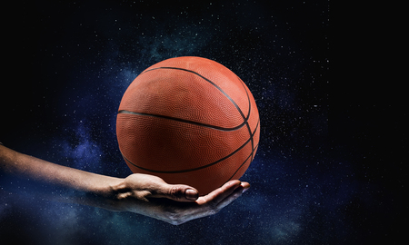 Hand of businessman holding in palm basketball ballの写真素材