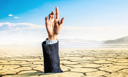 Hand coming out of ground as concept for never give upの写真素材