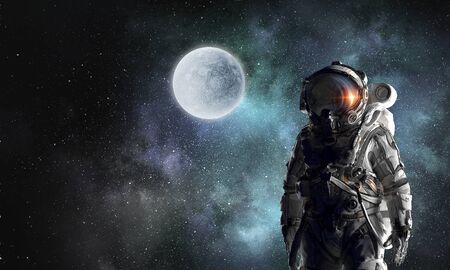 Astronaut against dark night sky background. Mixed mediaの写真素材