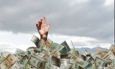 Rich businessman sink in pile of money banknotesの写真素材