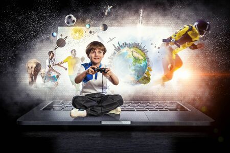 Boy playing a video game. Mixed mediaの写真素材