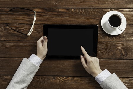 Top view of businesswoman sitting at table and using tablet pcの写真素材