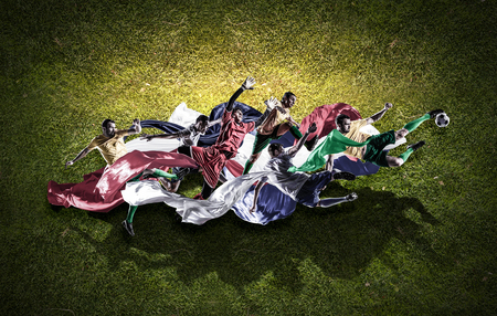 Soccer player with ball on green grass backgroundの写真素材