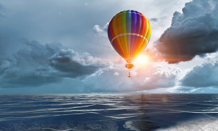 Color aerostat in sky with clouds fly over the sea. Mixed mediaの写真素材