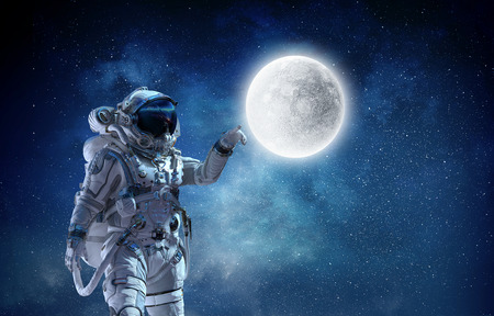 Astronaut pointing with finger on moon planet.の写真素材