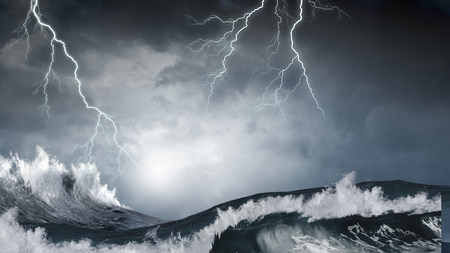 Dark clouds and crashing ocean waves during stormの写真素材