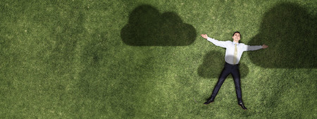 Businessman relaxing on grassの写真素材