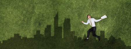 Pensive businessman on grassの写真素材