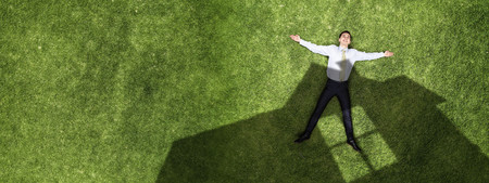 Pensive businessman on grassの写真素材