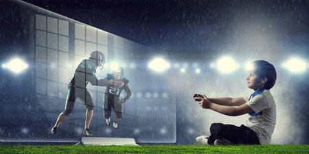 Boy playing a video game. Mixed mediaの写真素材