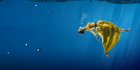 Woman dancer in clear blue waterの写真素材