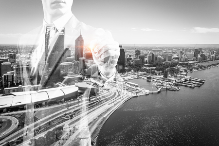 Businessman against modern city background draw on screenの写真素材