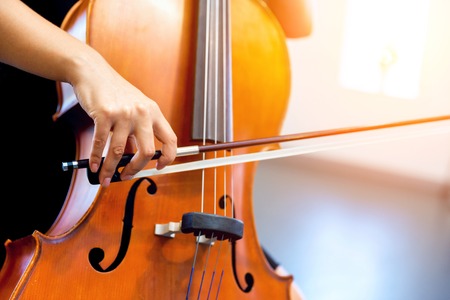 Close up of cello with bow in handsの写真素材