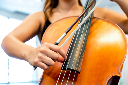 Close up of cello with bow in handsの写真素材