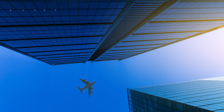 Airplane above business cityの写真素材