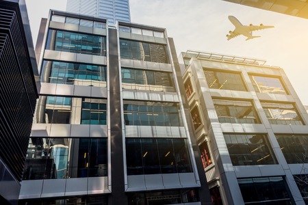 Airplane above business cityの写真素材