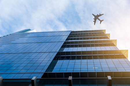 Airplane above business cityの写真素材